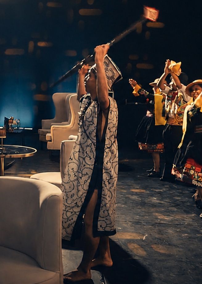 Bailarín con vestimenta de diseño amazónico alzando una lanza